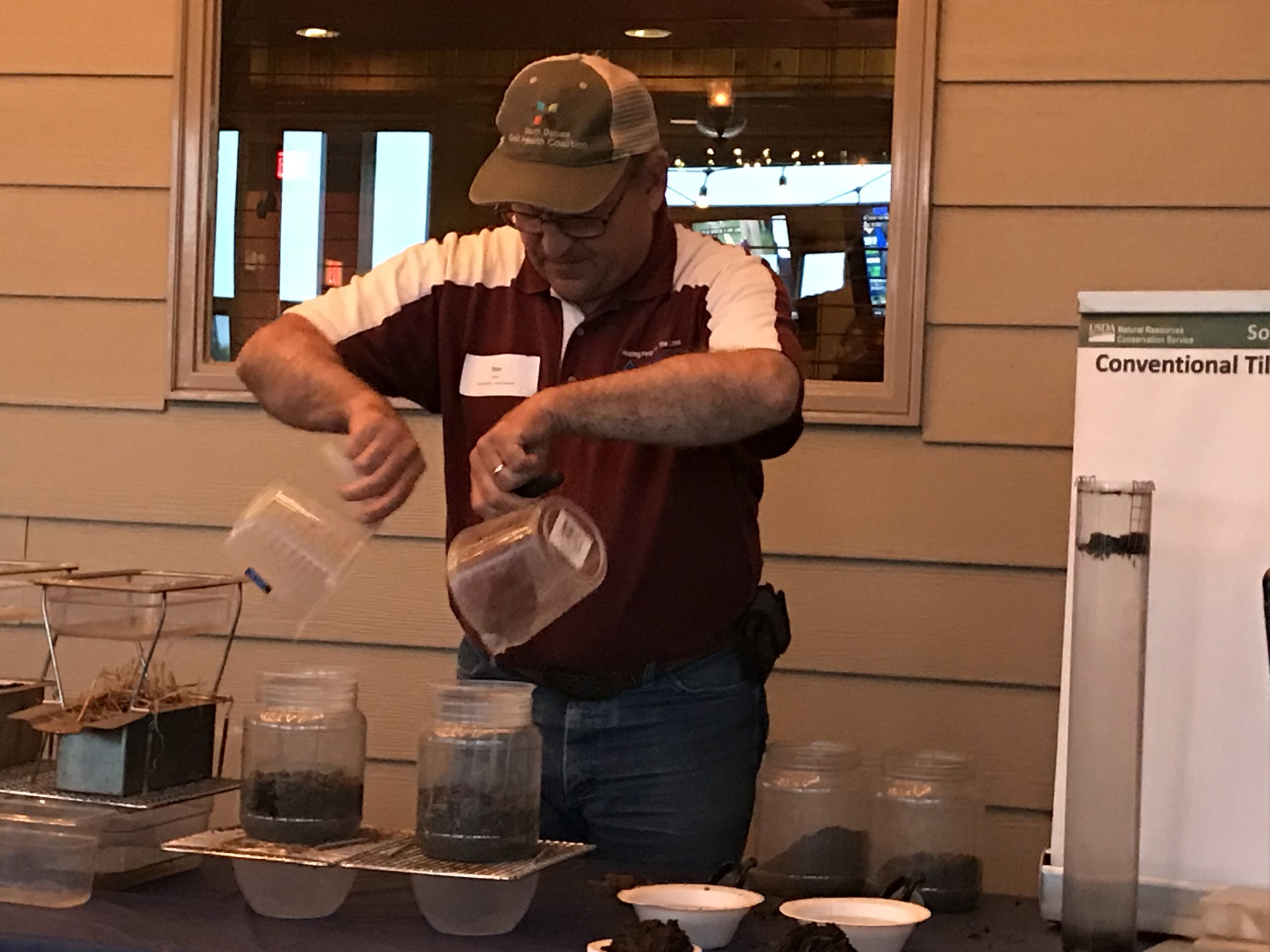 Stan Boltz demonstrating infiltration with jars of soil