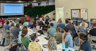 People sitting in a barn listening to a soil health presentation